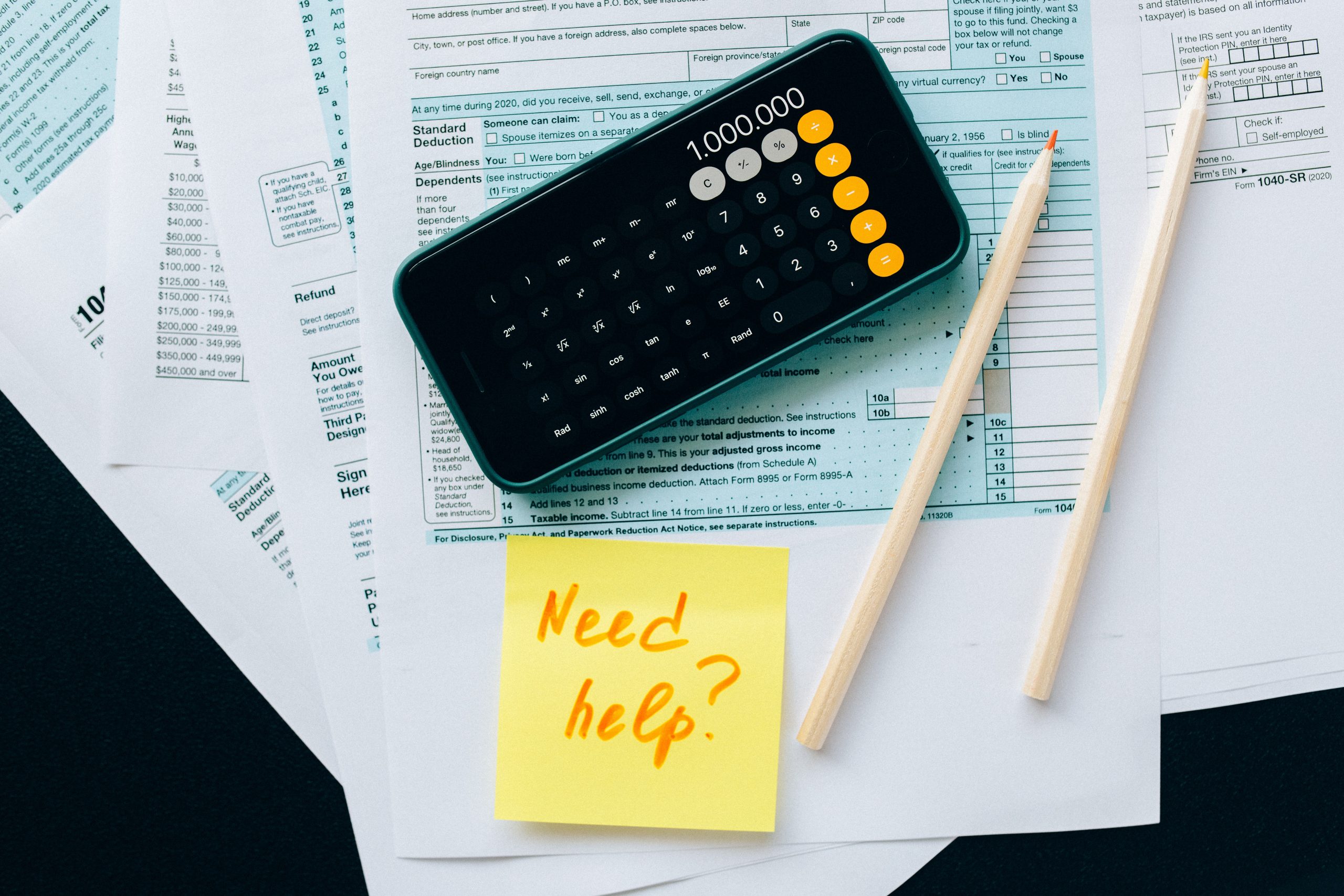 A phone with a calculator on top of financial documents