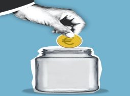 A hand placing a coin into a jar