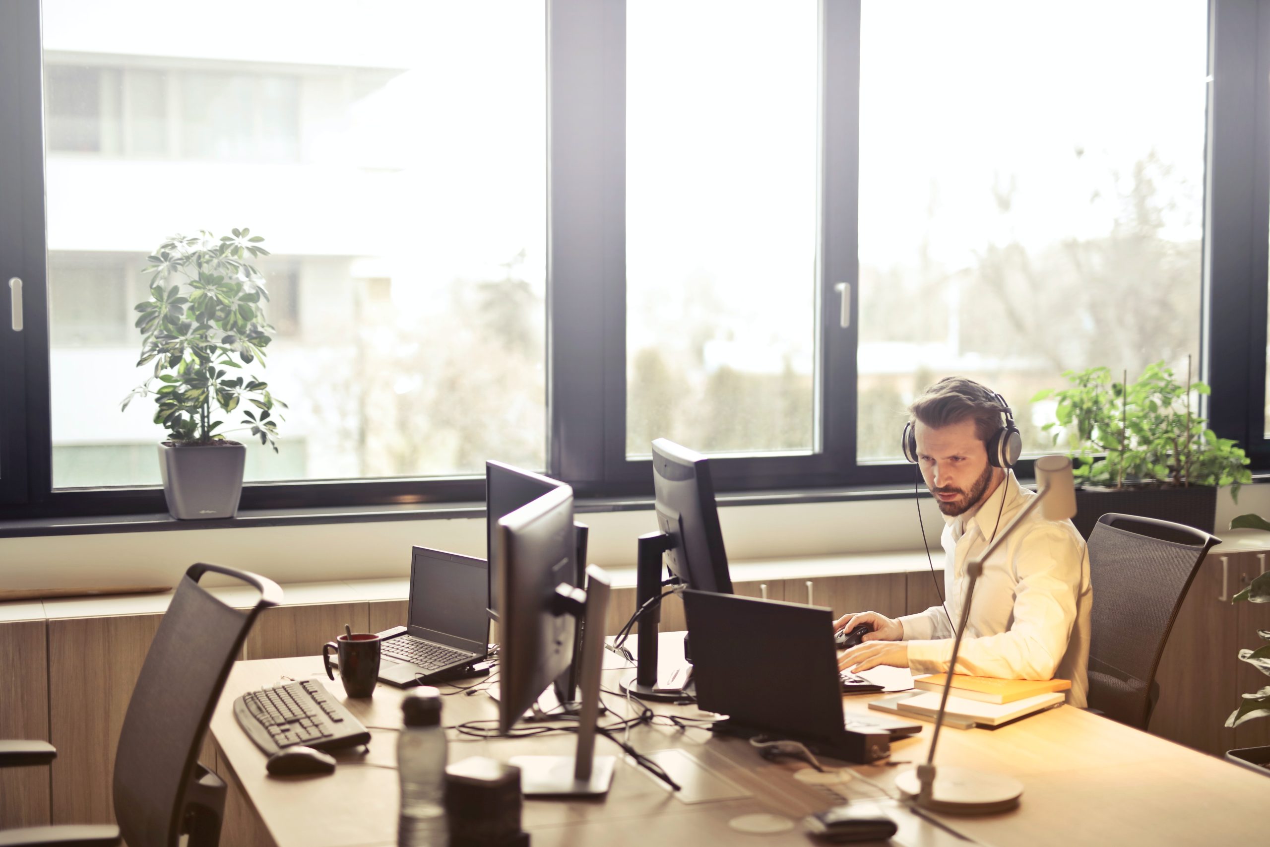 Man sitting at a computer desk with headphones on