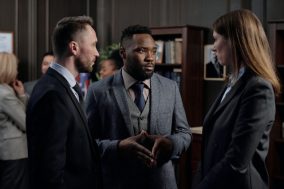 Three people in suits having a conversation