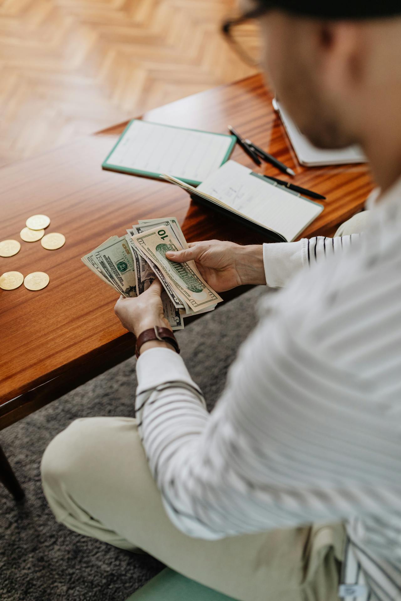 person holding a fan of us dollar bills